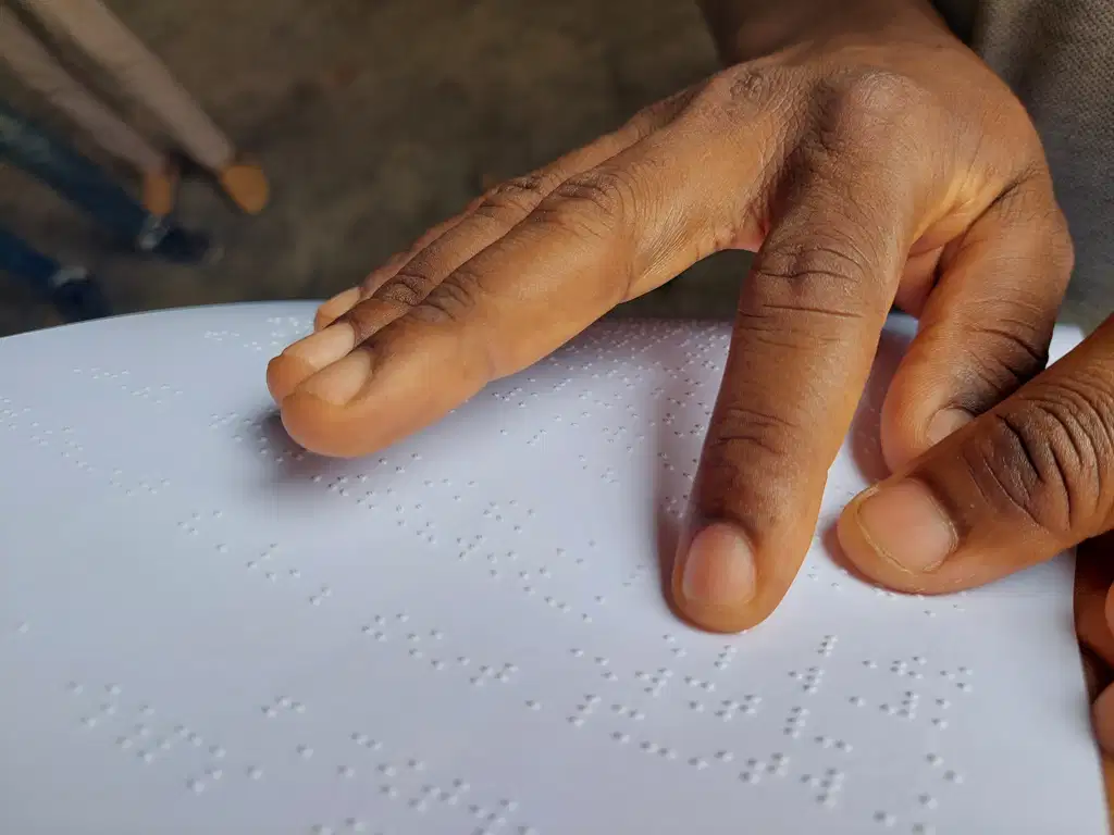 Les doigts d'une personne lisent une page de Braille